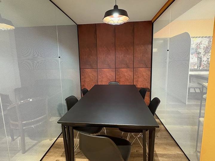 Sala privativa com paredes de vidro e mesa para seis pessoas